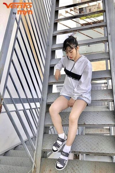 Cô gái trẻ tạo dáng với giày sandal nữ cá tính và áo thun dáng rộng