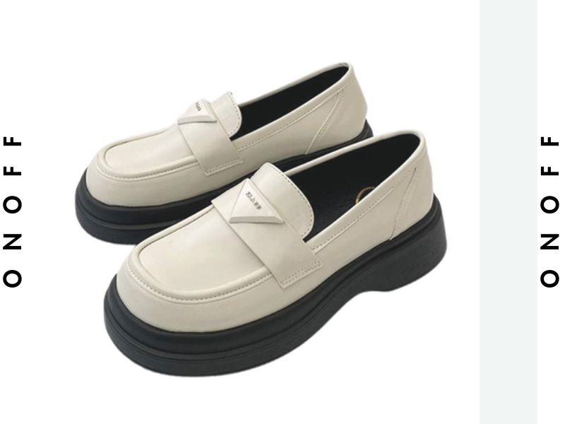 Giày oxford nữ vintage đen phối cùng quần kẻ caro và áo vest, tạo nên phong cách công sở cổ điển.