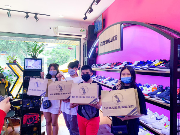 Người phụ nữ đeo giày sneaker trắng trong cửa hàng Kingshoes tại TP.HCM, thể hiện sự thoải mái khi chọn giày