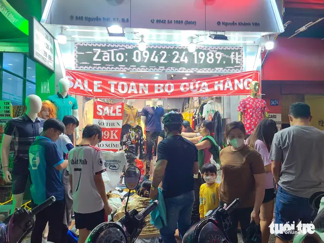Một cửa hàng quần áo trên đường Nguyễn Trãi (quận 5) xả kho toàn bộ cửa hàng, khách mua vây kín sạp - Ảnh: NHẬT XUÂN Một cửa hàng quần áo trên đường Nguyễn Trãi (quận 5) xả kho toàn bộ cửa hàng, khách mua vây kín sạp - Ảnh: NHẬT XUÂN